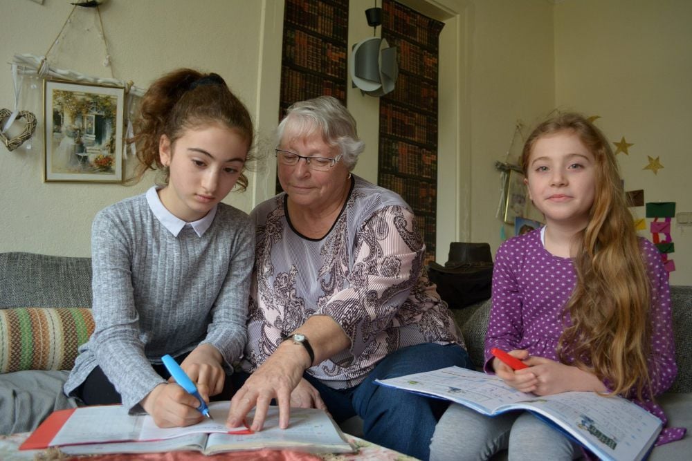 Helga Knittel hilft der neunjährigen Nour (links) und ihrer zwei Jahre jüngeren Schwester Rimas bei den Hausaufgaben.