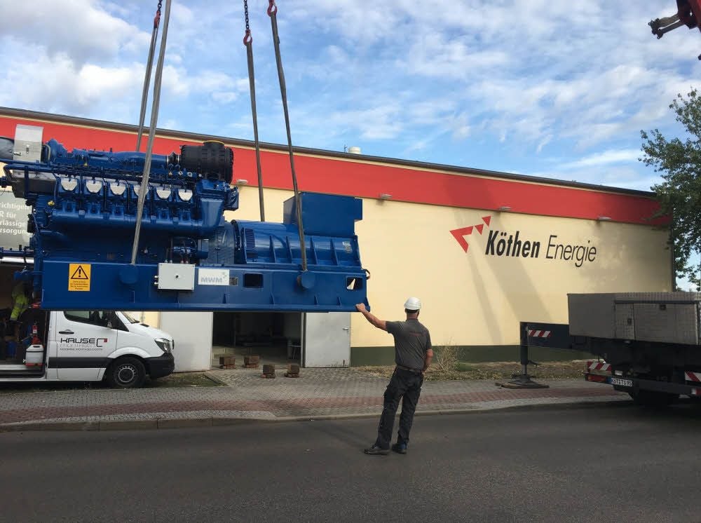 Das von der Firma MWM gefertigte Blockheizkraftwerk hängt am Autodrehkran und geht nun auf die letzte Etappe der langen Tour von Mannheim nach Köthen - 20 Meter von der Straße bis zur Endposition in der Halle von Köthen Energie.