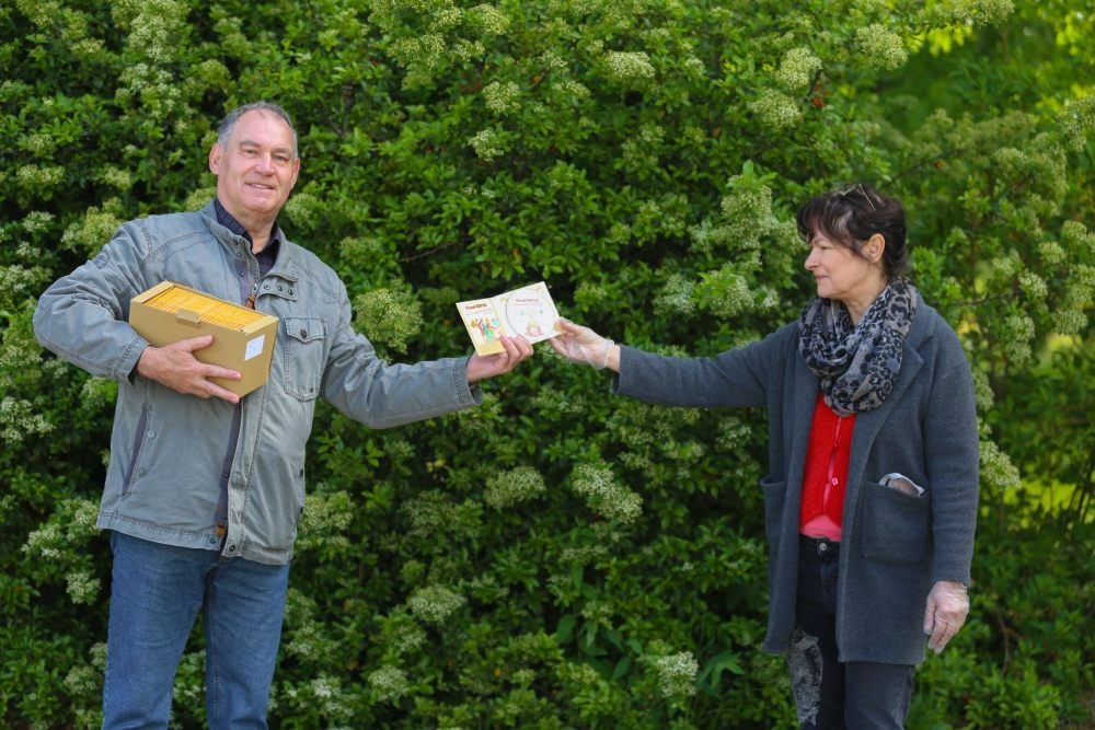Werner Fuhrmann überreicht der Leiterin der Müchelner Stadtbibliothek Karin Linke einen ganzen Karton seiner Kinder-CD.