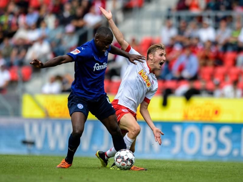 Marc Lais von Regensburg (r) gegen David Kinsombi von Holstein Kiel im Zweikampf. Foto: Matthias Balk