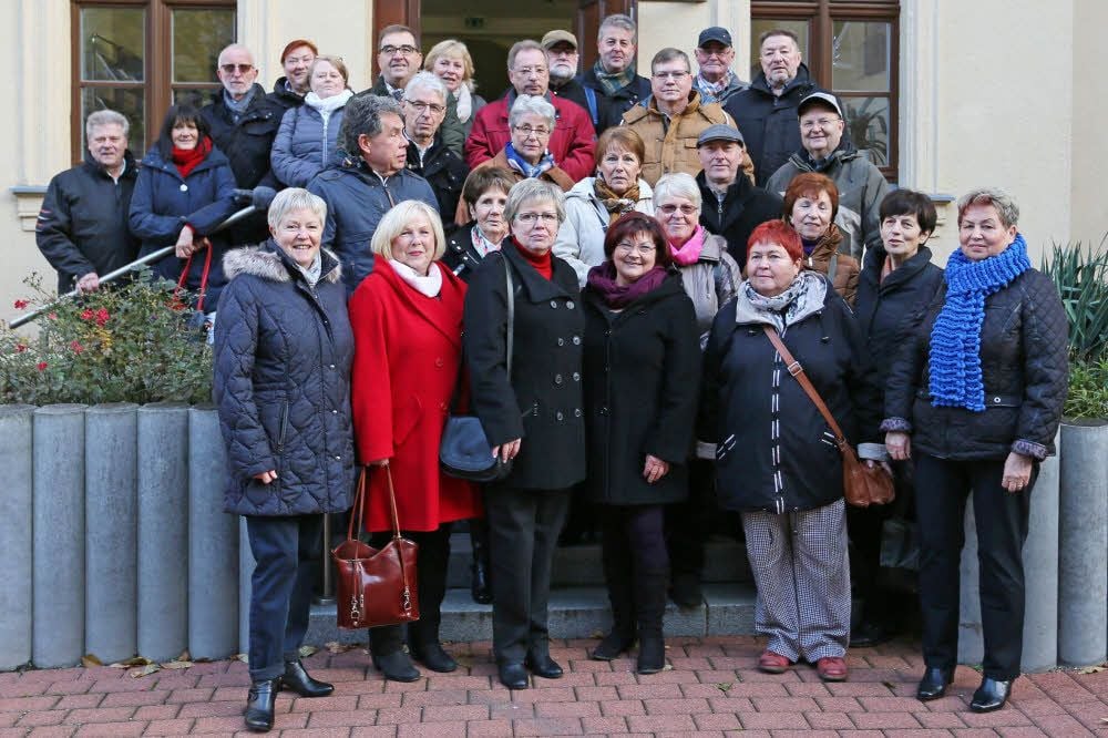 Die ehemaligen Schüler der Lübenschule in Aschersleben stellen sich für ein Klassenfoto nach 60 Jahren auf.