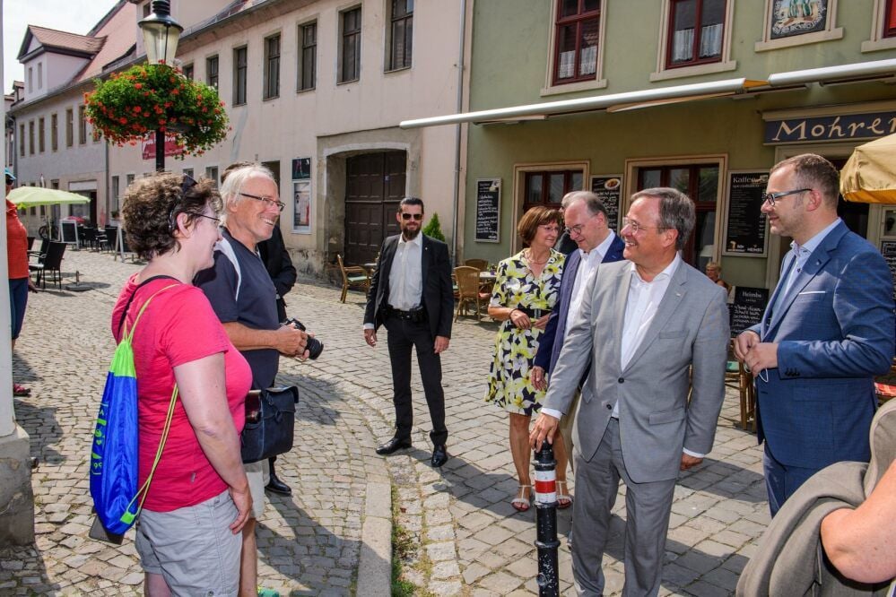 Bevor sich Armin Laschet im Beisein von Ministerpräsident Reiner Haseloff (r.) und Oberbürgermeister Bernward Küper (l.) in das Goldene Buch der Stadt einträgt, kommt er auf dem Weg zum Dom im Steinweg mit Bürgern ins Gespräch.