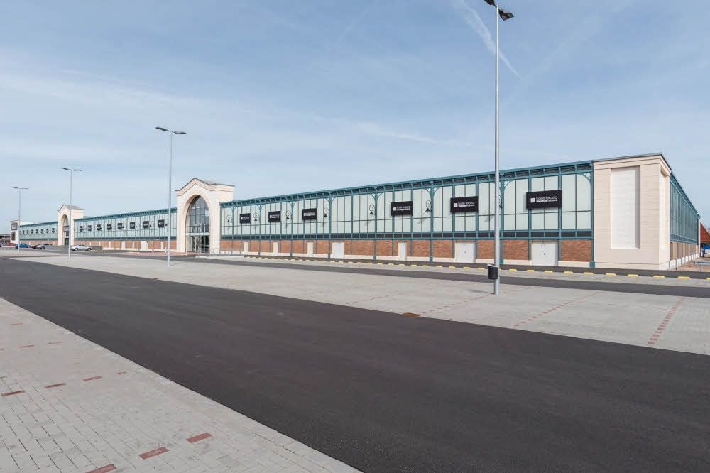 Das Outlet-Center von außen: Während sich im vorderen Teil knapp 50 Geschäfte befinden, ist der hintere Teil noch leer.