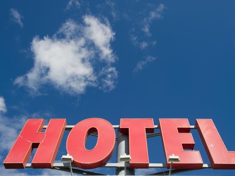 Der Schriftzug "Hotel" vor blauem Himmel. Foto: Stefan Sauer/ZB/dpa/Archiv