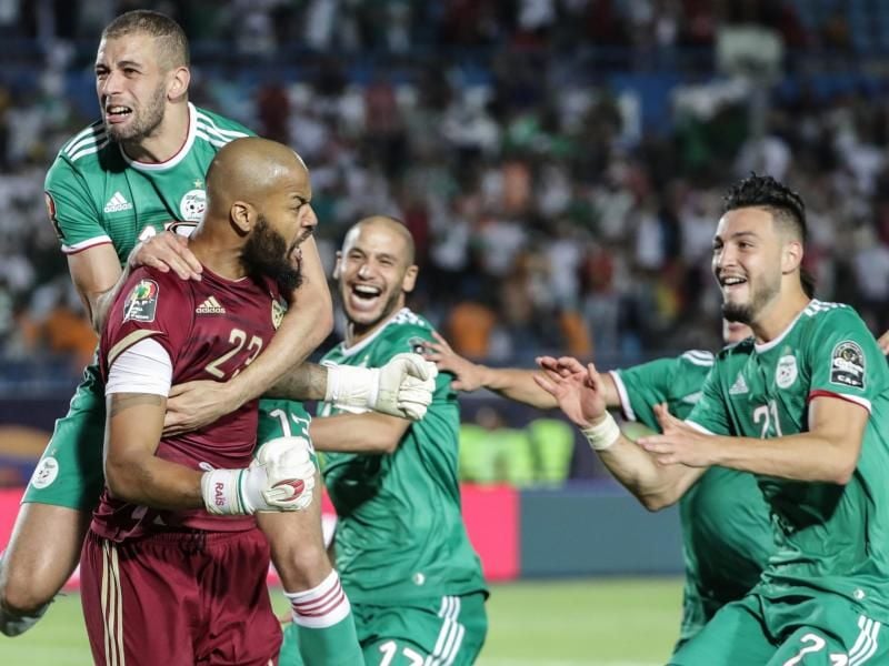 Algeriens Keeper Rais M'Bolhi(l) feiert mit seinen Teamkollegen das gegen Elfenbeinküste gewonnene Elfmeterschießen. Foto: Oliver Weiken