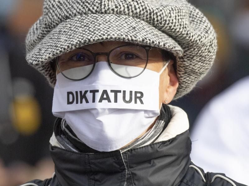 "Diktatur" steht auf der Nase-Mund-Bedeckung" einer Teilnehmerin an einer "Querdenken"-Demonstration in Frankfurt am Main. Foto: Boris Roessler/dpa