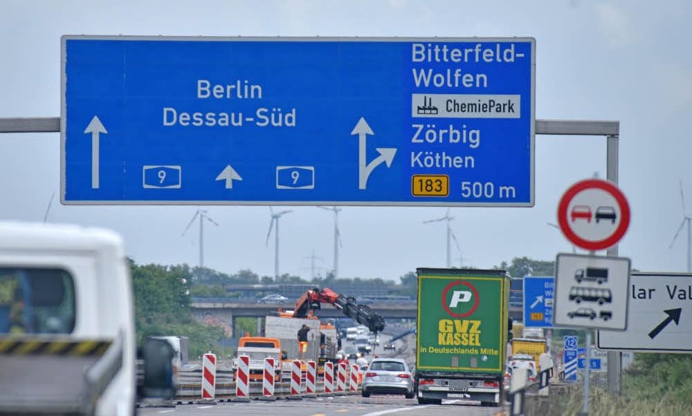 Mit einem Kran setzen Bauarbeiter die mobilen Schutzwände für die Bauphase.