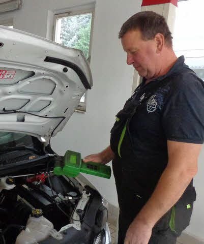 Mitarbeiter Jonny Möbius prüft die Batterie eines Pkw.