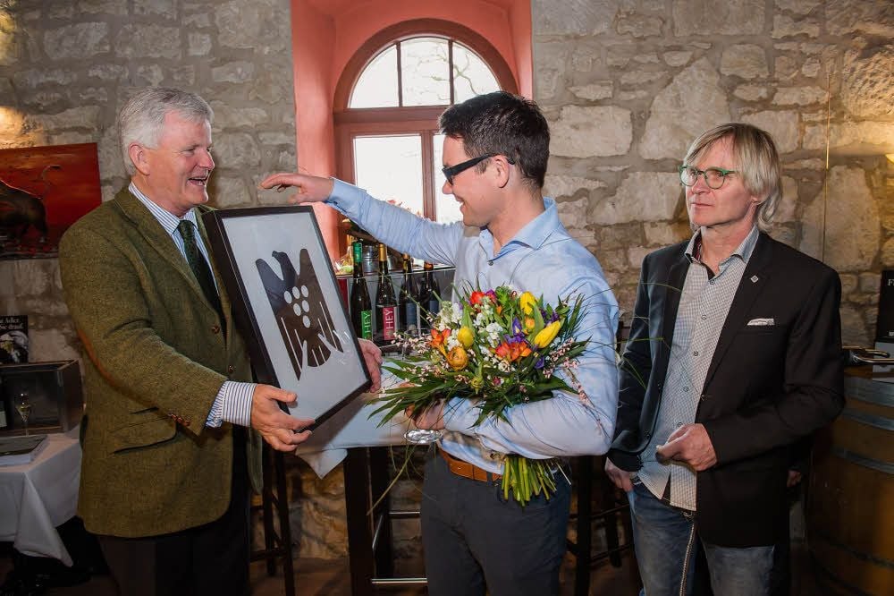 Zur feierlichen Aufnahme des Weingutes Hey in den Verband Deutscher Prädikatsweingüter übergibt Regionalvorsitzender Georg Prinz zur Lippe (l.) Matthias Hey den Traubenadler, im Beisein von Bernard Pawis (r.).