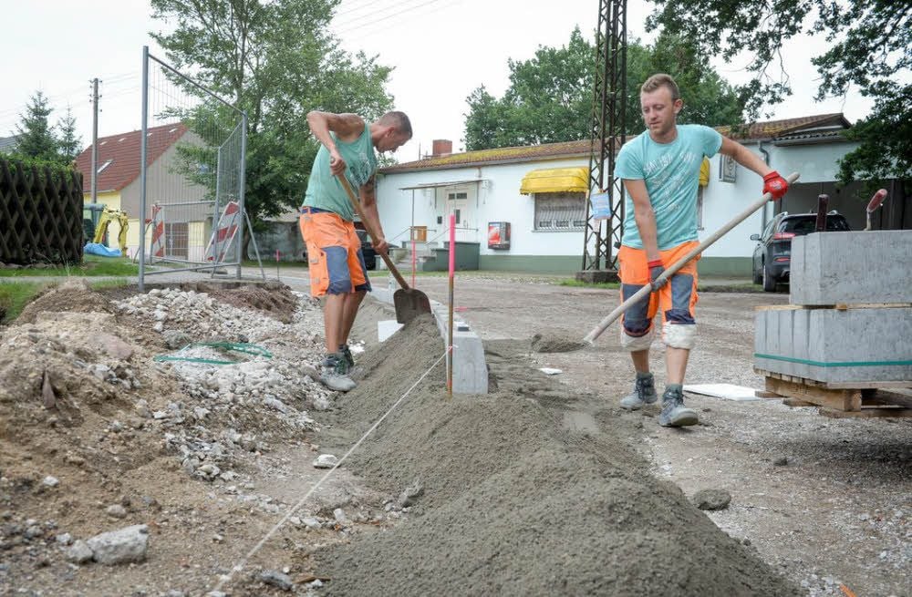 Baustelle Lindenstraße: Mitarbeiter der Firma Jaeger-Bau setzen die Borde für die Abgrenzung zum Fußweg.