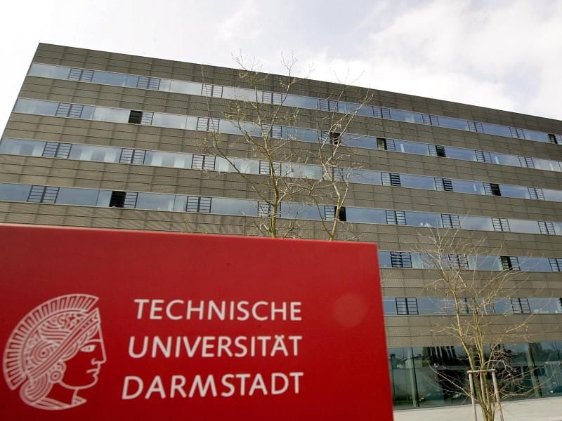 Ein Hinweisschild steht vor einem Gebäude der Universität in Darmstadt. Foto: Frank May/Archiv