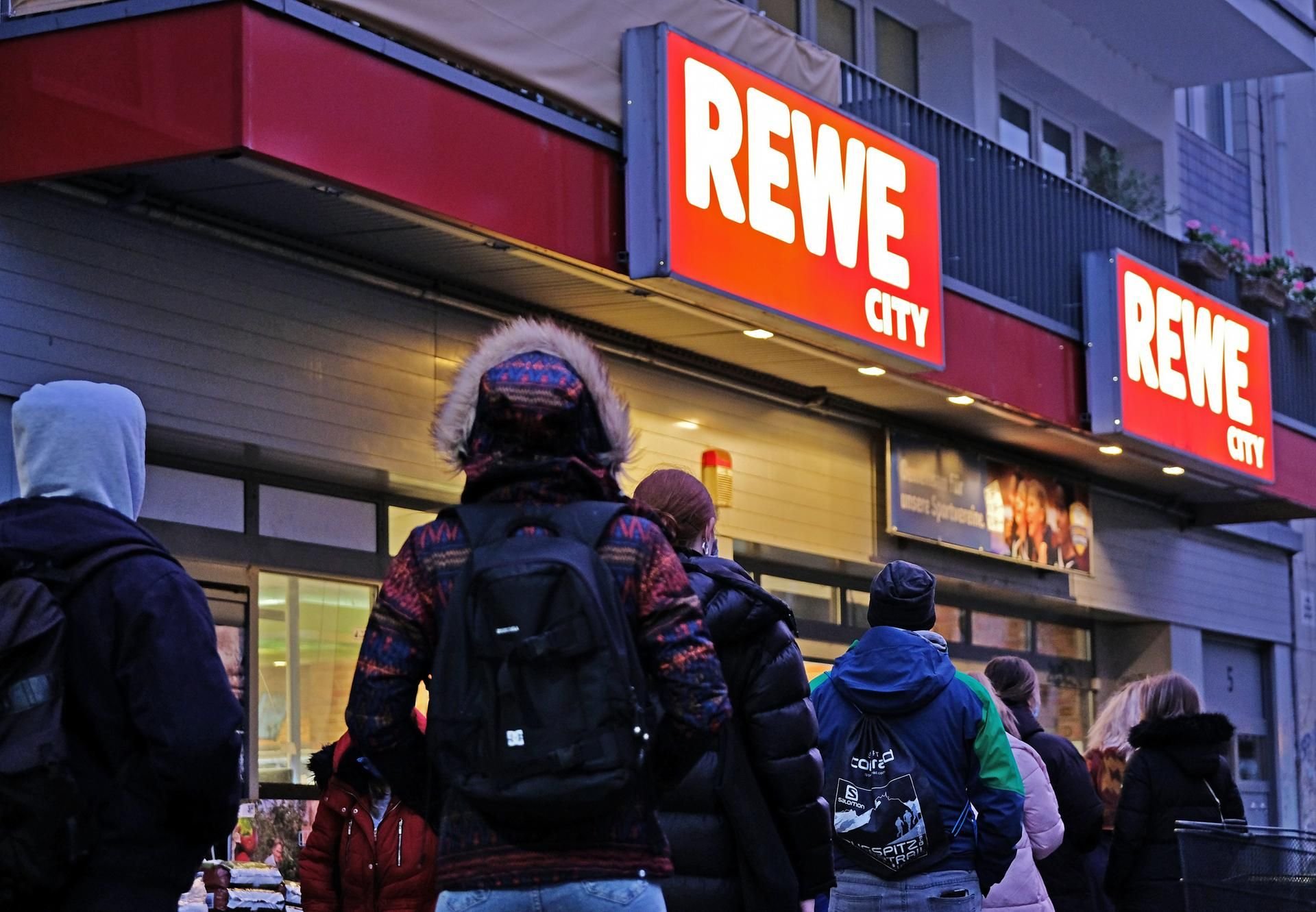 Menschen stehen vor einem Rewe-Markt in Köln (Symbolbild)