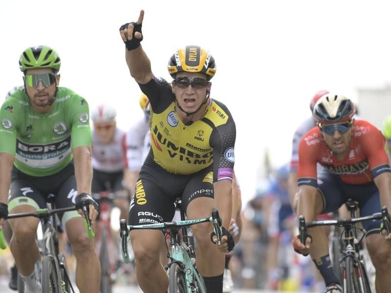 Der Niederländer Dylan Groenewegen (M) jubelt nach dem Überqueren der Ziellinie. Foto: Yorick Jansens/BELGA