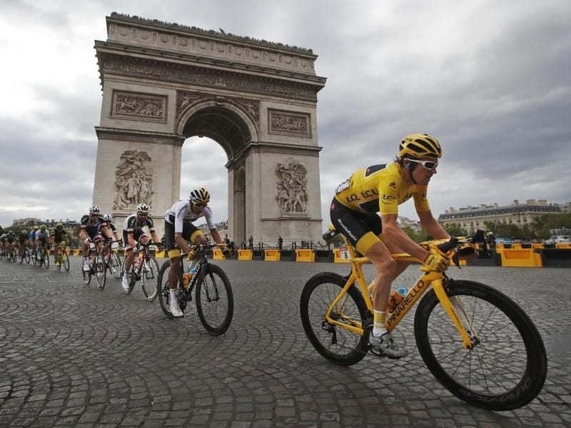Die Fahrer um Geraint Thomas (r.) passieren den Triumphbogen. Foto: Christophe Ena/AP