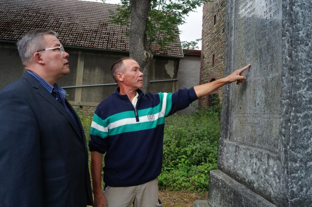 Landtagsabgeordneter Jens Diederichs (Freie Wähler) und Falk Belger (r.), Initiator der Sanierung, am Kriegerdenkmal in Thondorf