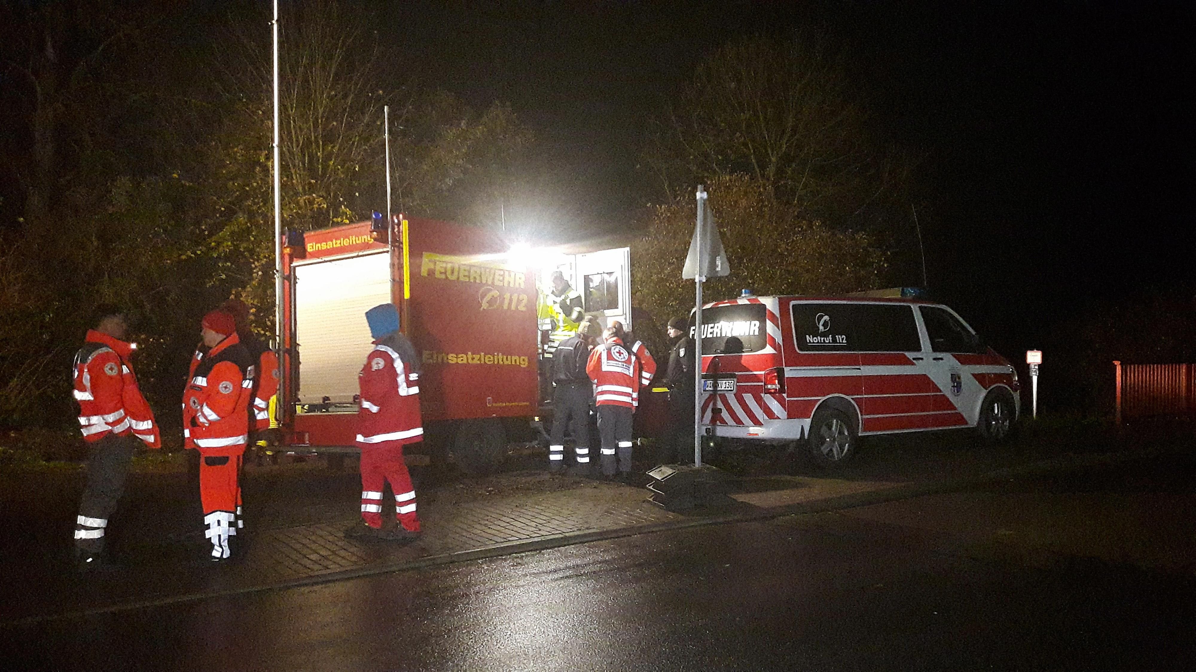 Feuerwehrleute und Rettungssanitäter stehen während der Suche nach einem vermissten einjährigen Jungen an der Werra bei Bad Salzungen.