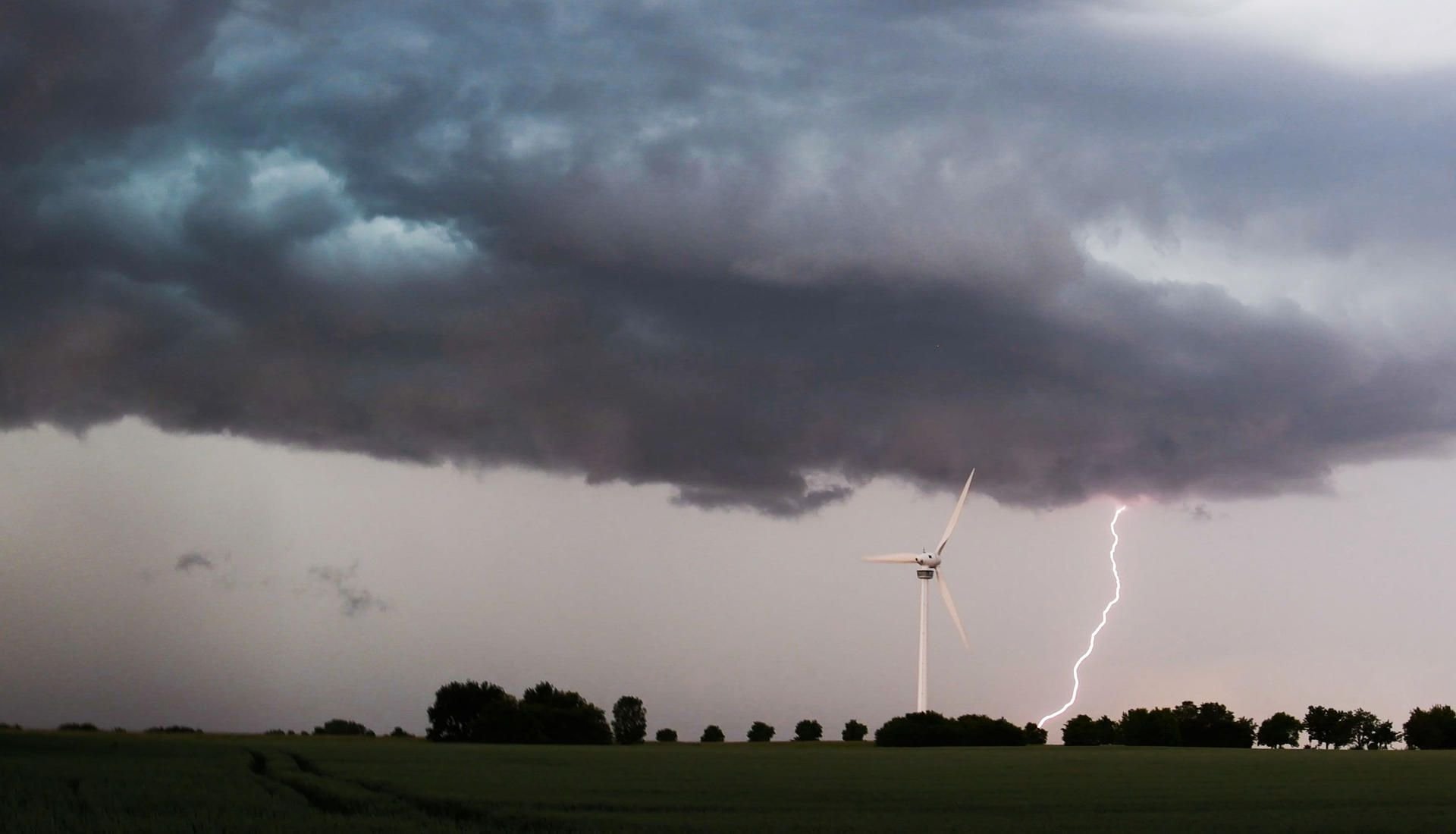 Eine Unwetterfront mit dunklen Regenwolken und Blitzschlägen zieht über die Region hinweg.