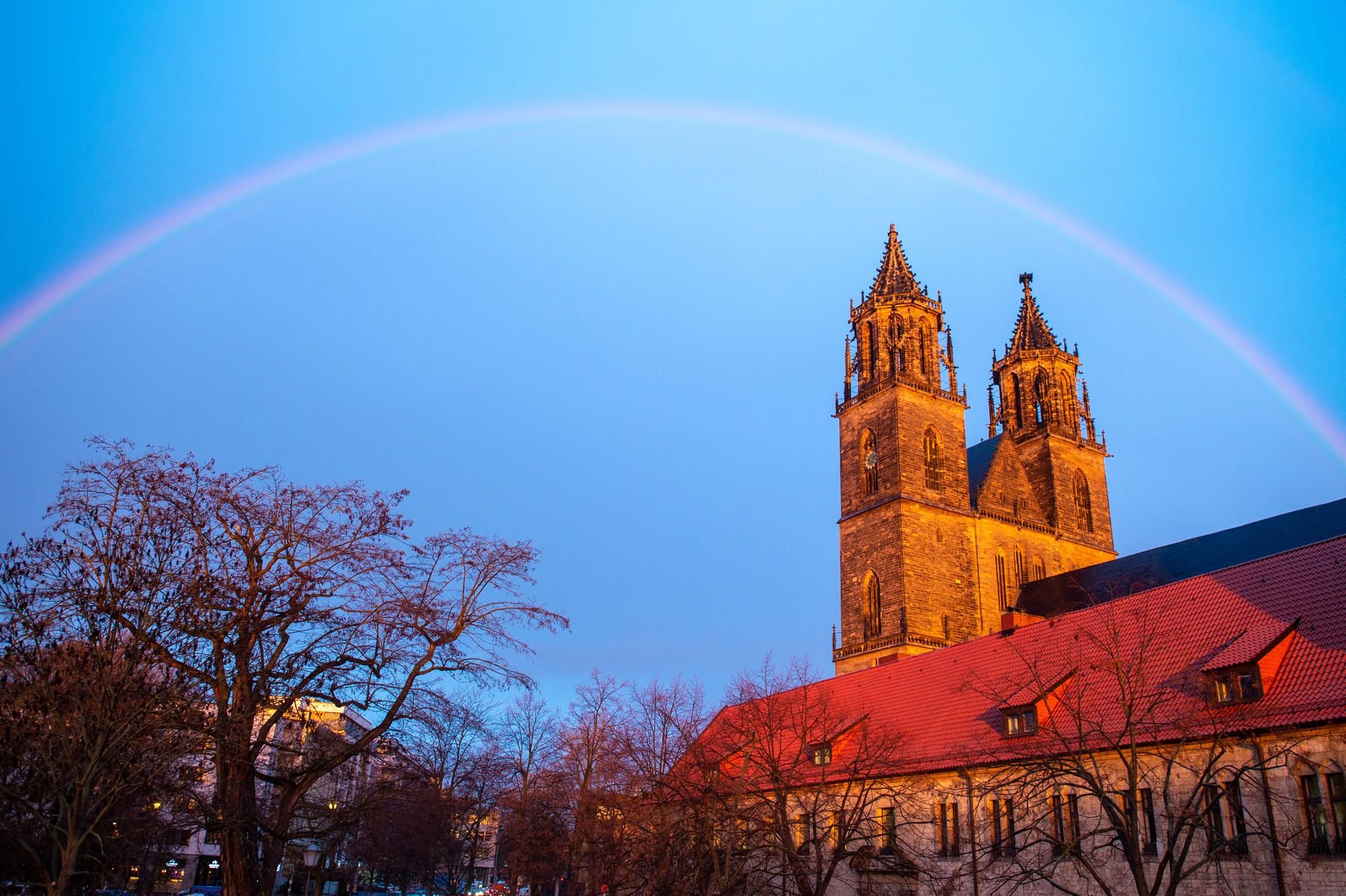 Ein Regenbogen steht am frühen Morgen über dem Magdeburger Dom.