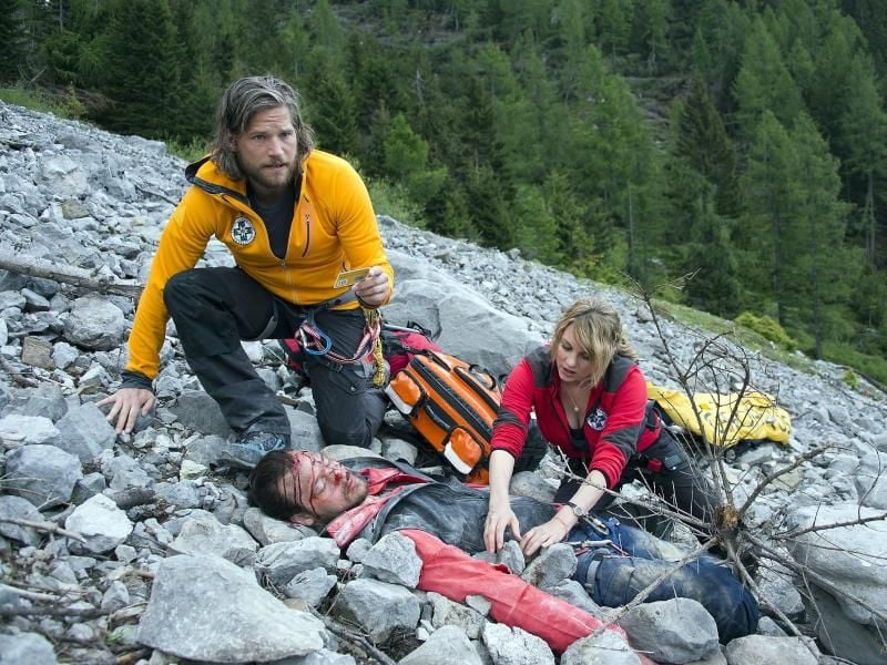 Die Bergretter Markus (Sebastian Ströbel) und Katharina (Luise Bähr) finden den abgestürzten und schwer verletzten Jan Fugain (Patrick G. Boll). Foto: Thomas R. Schumann/ZDF