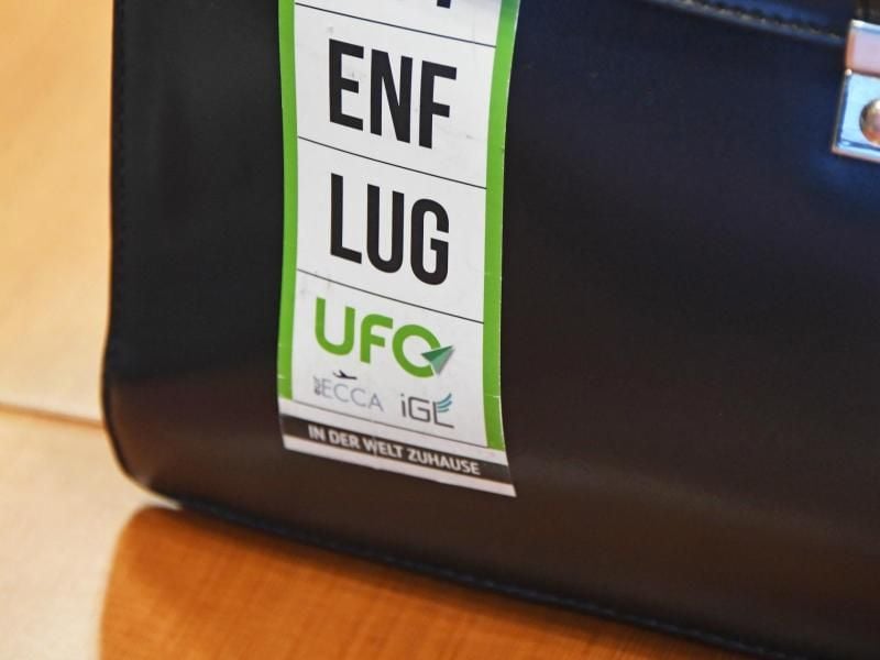Auf einer Tasche ist ein Aufkleber der Flugbegleitergewerkschaft UFO angebracht, auf dem zu lesen ist "GUTENFLUG UFO". Foto: Uli Deck/Archiv