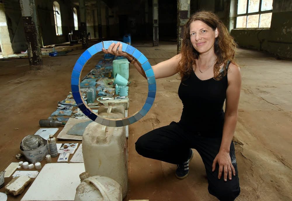 Esther Kokmeijer zeigt ein selbst gebautes Cyanometer. Für ihre Installation hat sie Dinge gesammelt, die aufgereiht den Farbübergang von Weiß über Blau zu ganz dunklem Blau zeigen.