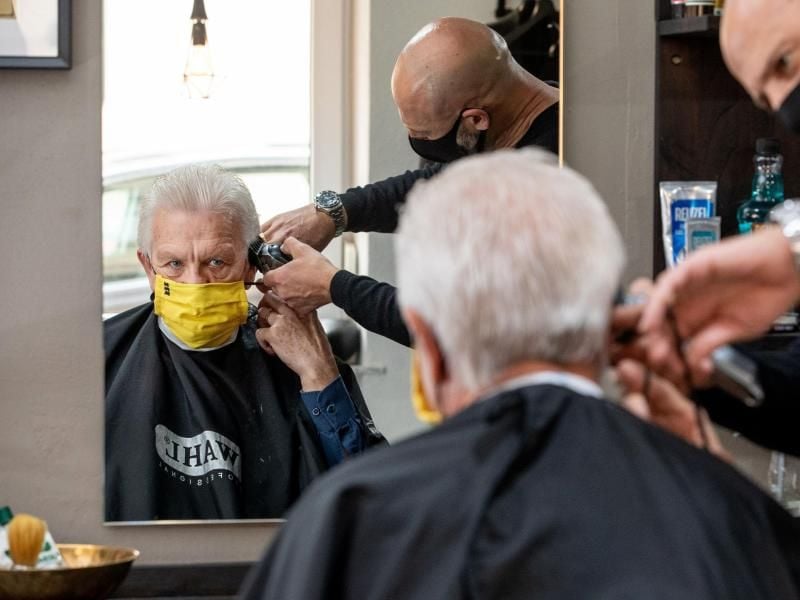 Winfried Kretschmann (Bündnis 90/Die Grünen) beim Friseur - selbstverständlich mit Maske. Foto: Staatsministerium/Staatsministerium Baden-Württemberg/dpa
