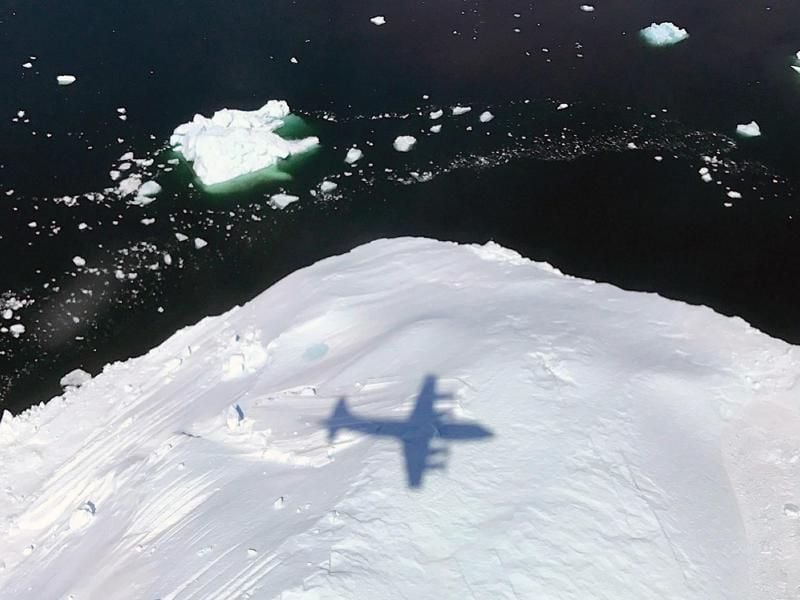 Der Schatten eines NASA-Flugzeugs auf einem Eisberg im Südosten von Grönland zu sehen. Das Flugzeug sammelt Daten von möglichen Veränderungen des Eises. Foto: Joe MacGregor/NASA