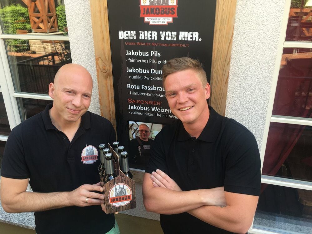 Bald gibt es das Köthener Sterne-Bier „Jakobus“ auch in handelsüblichen Flaschen: Stephan Nickel (l.) und Romeo Sarközi zeigen schon mal, wie das aussehen könnte - und Brauhaus-Brauer Matthias Hankel ist wenigstens als Foto bei der Präsentation dabei.