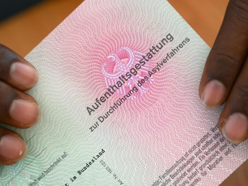 Er hat es geschafft: Ein somalischer Flüchtling hält eine Aufenthaltsgestattung in den Händen. Foto: Arne Dedert