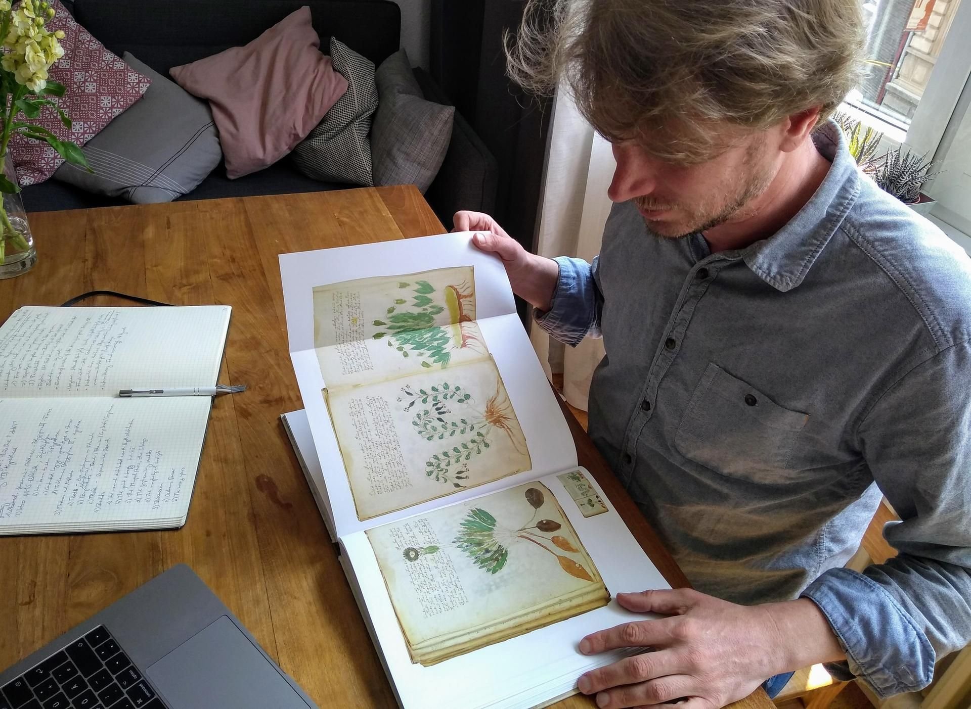 Jürgen Hermes, Computerlinguistiker von der Universität Köln, studiert ein Faksimile des reich bebilderten, aber bislang nicht entschlüsselten Voynich-Manuskripts aus dem 15. Jahrhundert.
