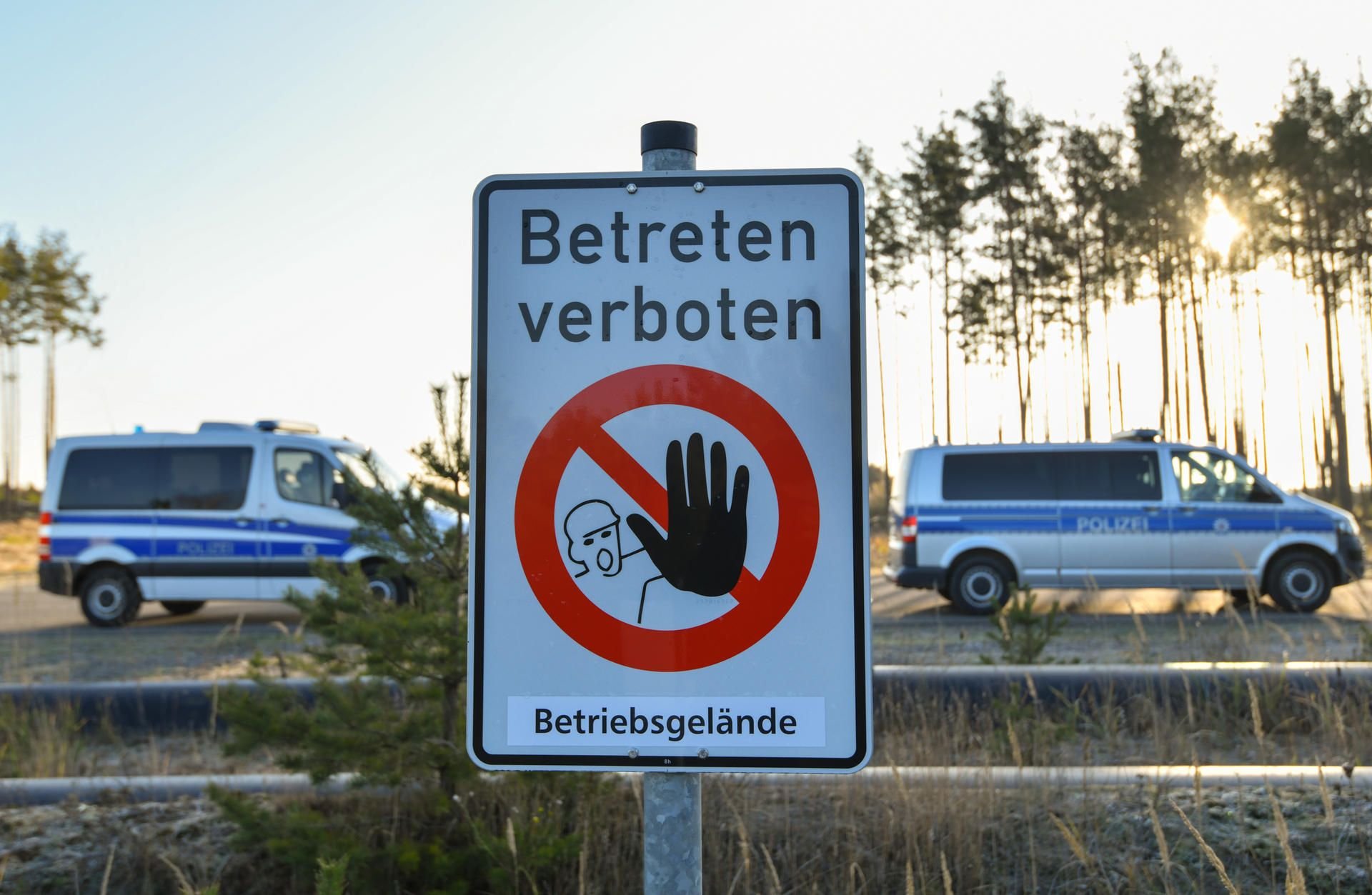 Ein Schild mit der Aufschrift «Betreten verboten Betriebsgelände» und Fahrzeuge der Polizei stehen am Rand des Braunkohletagebaus Jänschwalde.