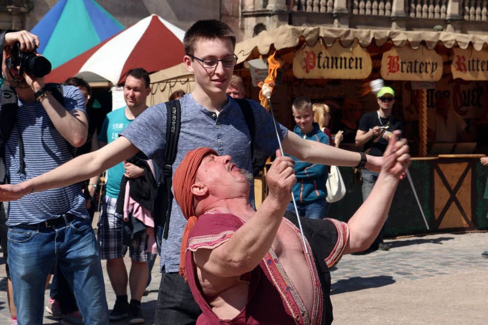 Fakir Rudolfo (vorn) schluckt mit Assistenz eines Besuchers die brennende Fackel.