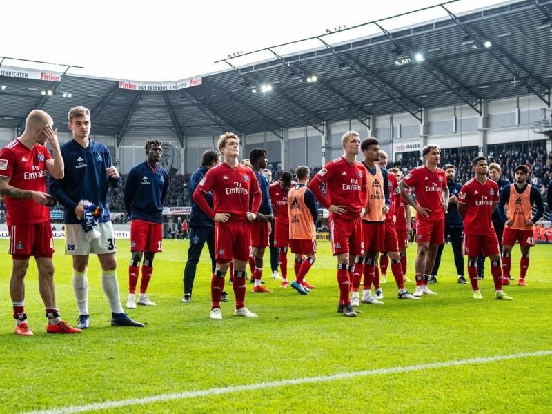 Die Spieler vom Hamburger SV stehen nach dem Spiel enttäuscht und geknickt auf dem Platz. Foto: Guido Kirchner
