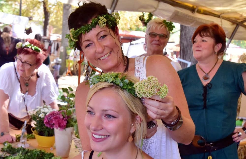 Ein Hauch von Mittelalter-Mode auf dem Kopf : Das war ein neues Angebot der Bierkrieger-Frauen, hier Silke Uhlemann, die Antonia Solty einen Kranz flicht.