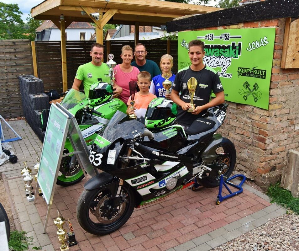 Jens (l.) und Jonas Kindermann (r.) freuen sich über ihre auf dem Motorrad erkämpften Erfolge. Die Familie, Mutter Yvonne, Manager Armin Schulschewski und Jonas’ Freundin Martha, steht voll zum Hobby der beiden.