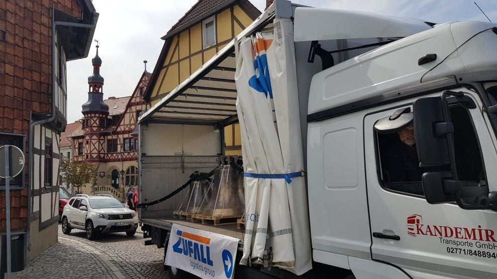Der Lkw mit den Glocken fährt im Schritttempo durch Harzgerode, Pfarrer Cord Exner auf dem Beifahrersitz.