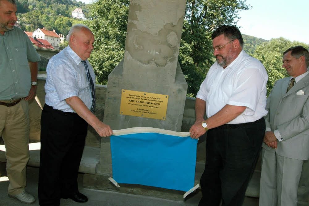 Eine 2005 eingeweihte Tafel weist darauf hin - hier mit Martin Kathe und dem damaligen Bürgermeister Christoph Emus -, dass Karl Kathe die Brücke vor der Sprengung bewahrt hat.