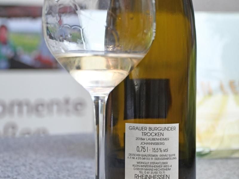 Bei einer Verkostung von Weinen steht ein Glas Wein neben einer Flasche Grauburgunder. Foto: Peter Zschunke/Archivbild