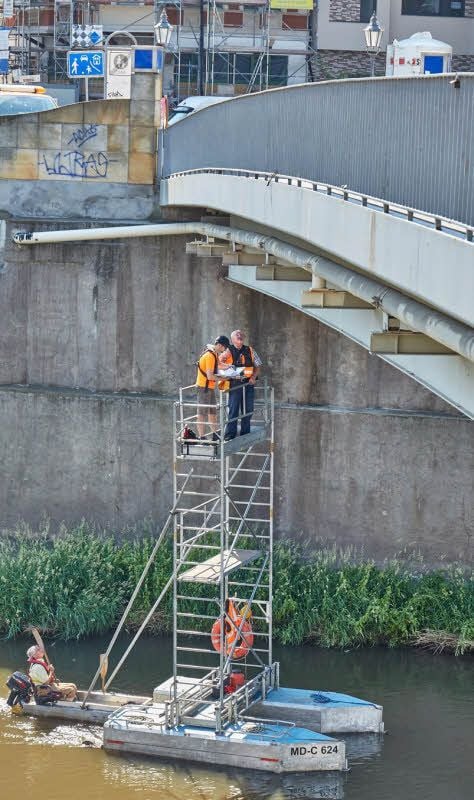 Mit einem Boot der Marke Eigenbau wurde die Bernburger Fußgängerbrücke am Dienstag auf Schäden überprüft.