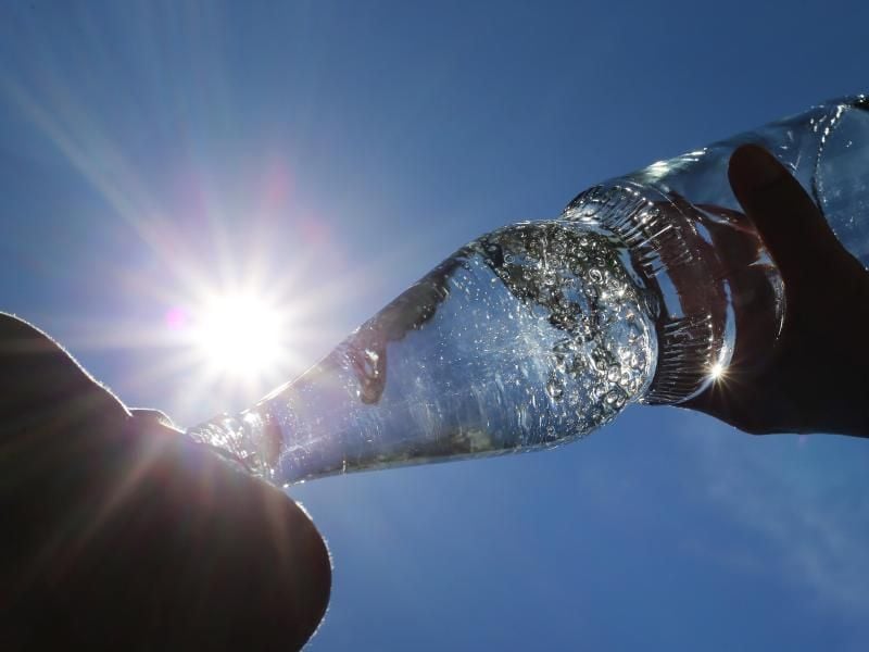 Eine Frau trinkt aus einer Flasche sprudelndes Mineralwasser. Foto: Karl-Josef Hildenbrand/dpa