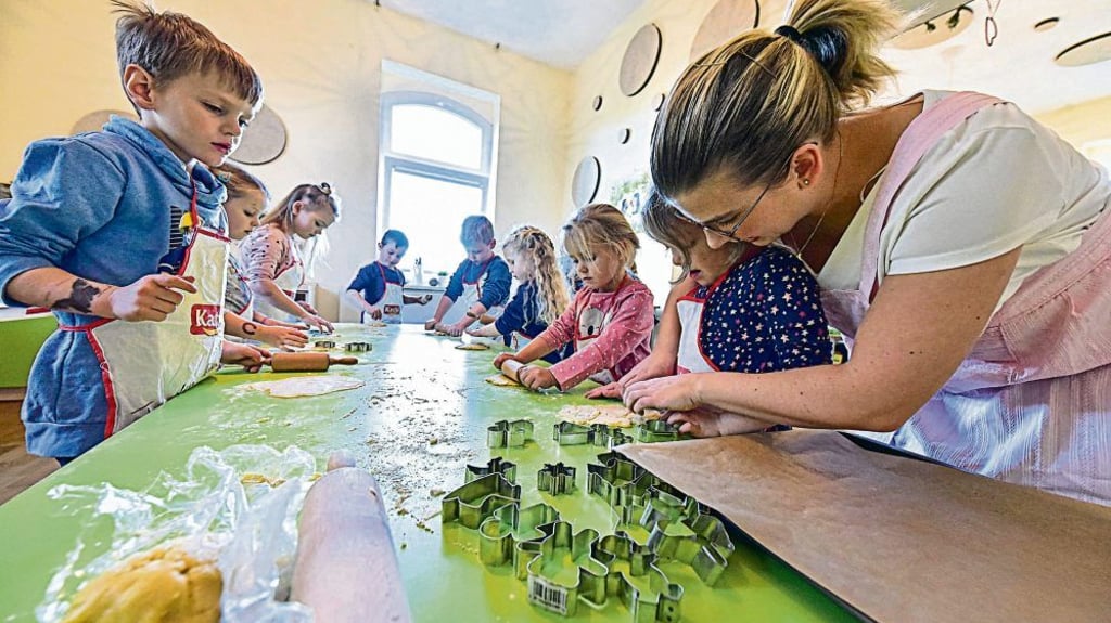 Caroline Kopelke vom Elternkuratorium (rechts) unterstützt die Drei- bis Sechsjährigen beim Backen in der Kinderlernküche.