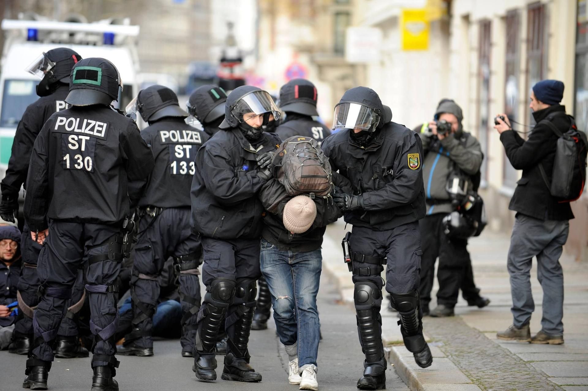 Polizisten führen während einer Demonstration am 12.12.2015 in Leipzig Teilnehmer einer Sitzblockade ab.