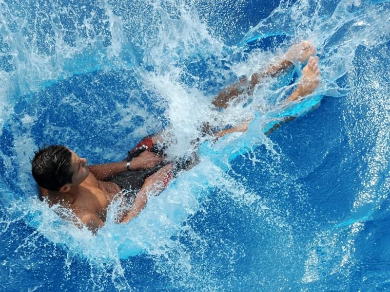 Ein Junge springt in einem Freibad ins Wasser. Foto: picture alliance / dpa/Symbolbild