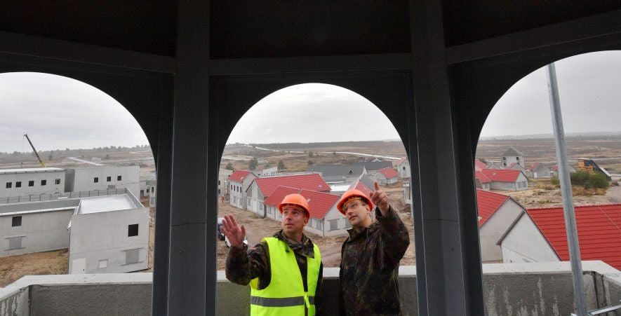 Oberstleutnant Manuel Nicolai (r) und Oberstabsfeldwebel Matthias Hähnel unterhalten sich während einer Besichtigungstour auf dem Turm des Sakralbaus auf der Baustelle des Ausbildungsgeländes der Bundeswehr Übungsstadt "Schnöggersburg" auf dem Truppenübungsplatz Altmark bei Gardelegen.