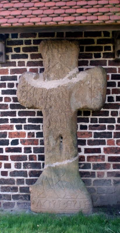 Das Axiener Steinkreuz - hier das reparierte Original an der Außenwand des Kirchturms - kann mit einer interessanten Geschichte aufwarten und nährt wegen etlicher unbeantworteter Fragen viele Vermutungen.