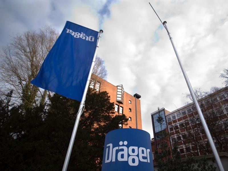 Eine Firmenflagge weht vor dem Hauptsitz des Unternehmens Drägerwerk. Foto: picture alliance/Axel Heimken/dpa/Archivbild