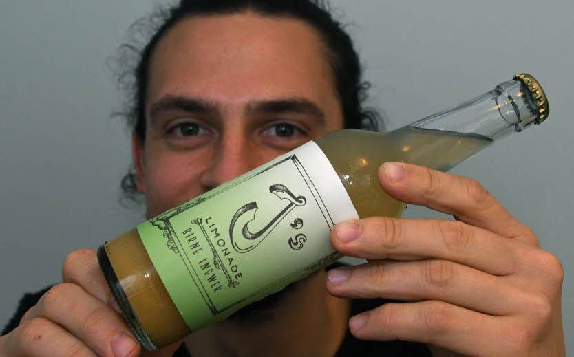 Jonas Groseker, Gründer der Marke „J's Limonade“, zeigt eine Flasche seiner Limonade Birne-Ingwer.