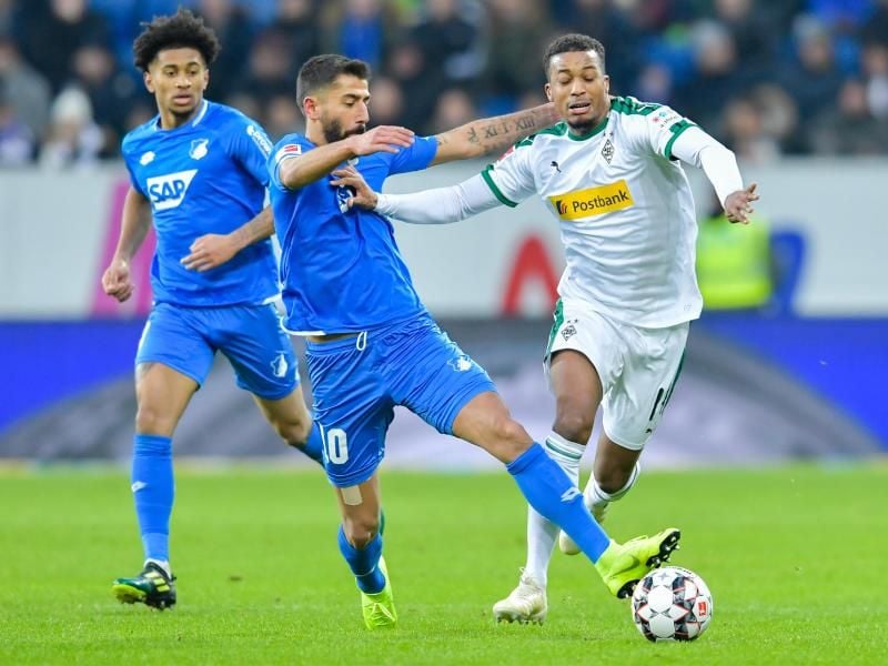 Die Hoffenheimer Reiss Nelson, Kerem Demirbay und Gladbachs Alassane Plea (l-r) im Zweikampf um den Ball. Foto: Uwe Anspach