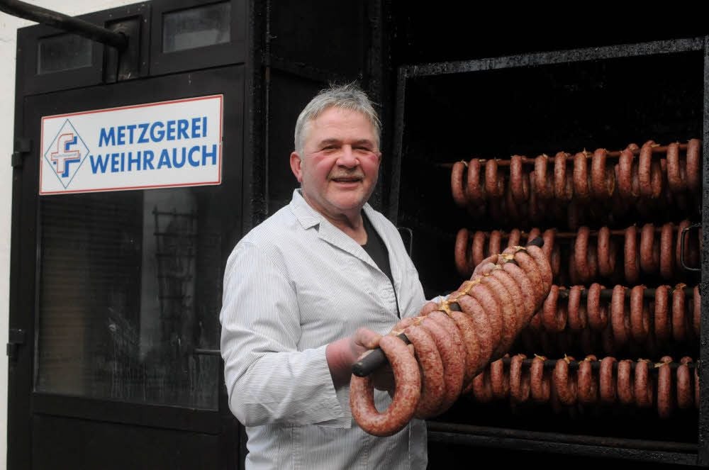 Am traditionellen Hausschlachte-Tag in seiner Lossaer Fleischerei holt Karl-Heinz Weihrauch Knackwürste aus dem Räucherofen.
