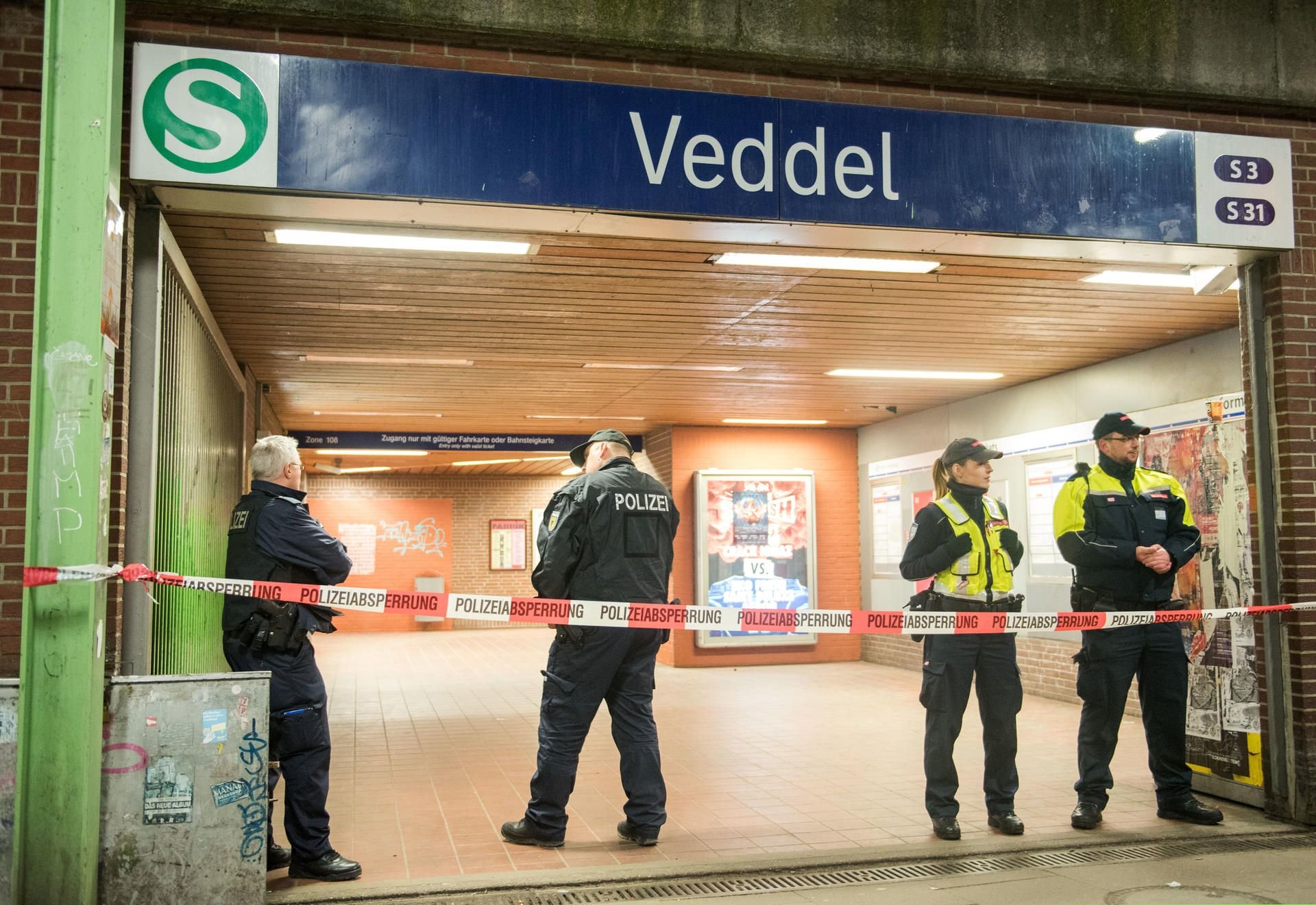 Polizisten und Angestellte des Sicherheitsdienstes der Bahn bewachen nach der Explosion den Eingang zum S-Bahnhof Veddel.